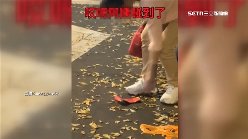 女子在地上看見紅包袋,誤以為裡頭有錢、伸手撿,才剛碰到紅包立刻意識到不對勁