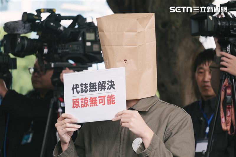 二二八受難者家屬第三代在蔣萬安致詞時舉牌抗議。（圖／記者楊士誼攝影）