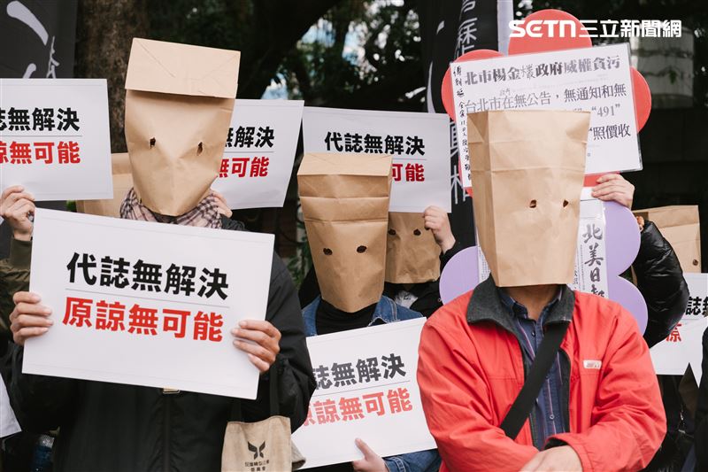 蔣萬安出席二二八追思儀式，場外民眾也戴上牛皮紙袋舉牌抗議。（圖／記者楊士誼攝影）