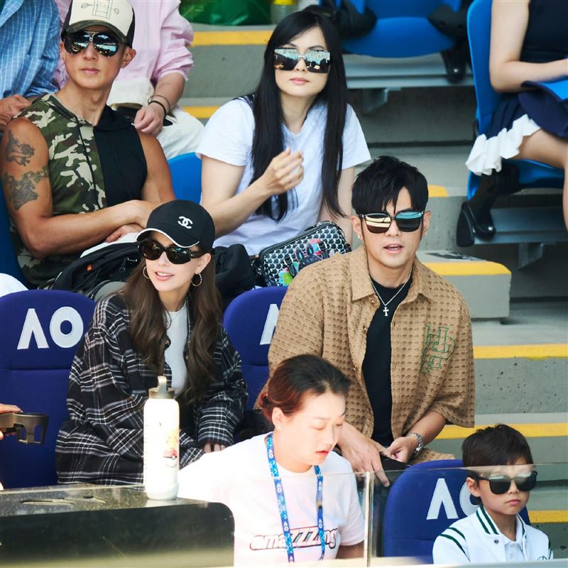 Romeo（右下）穿白色運動休閒外套、戴著墨鏡坐在觀眾席，外型和爸爸周杰倫超像。（圖／翻攝自微博）