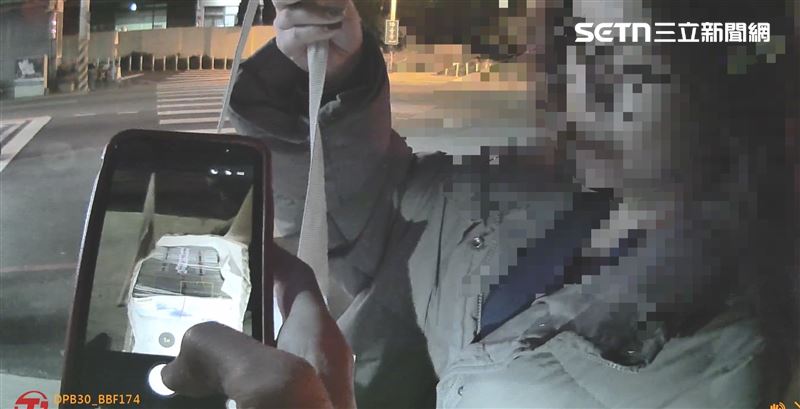 發現一名婦人路過該處，隨即將帆布袋撿起帶入室內。這名婦人簡直是該名男子的恩人，幫他撿起現金袋子保管。（圖／翻攝畫面）