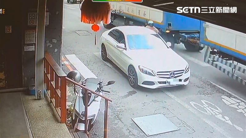 白色賓士車違停,女騎士在「夾縫中求生存」畫面曝光。(圖/翻攝畫面)