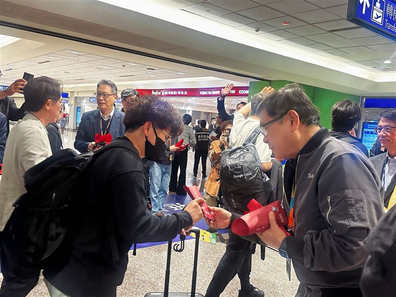 機場公司董事長楊偉甫(右)致贈旅客蘋果酥,象徵「平安回家」。(圖/桃園機場提供)