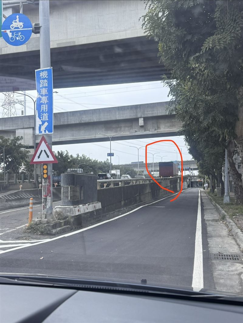 大貨車誤闖機車道，車身硬擠通過把路牌給刮壞。（圖／翻攝畫面）