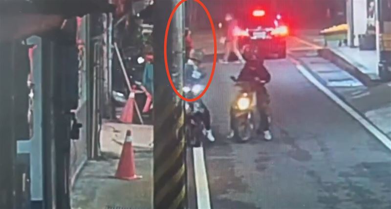 紅衣女被綁在路邊電桿上，還引來路人側目。（圖／翻攝畫面）