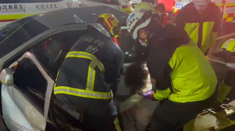 銀色轎車女駕駛一度受困車內，消防人員將人拉下車搶救。（圖／記者黃國瑞攝影）