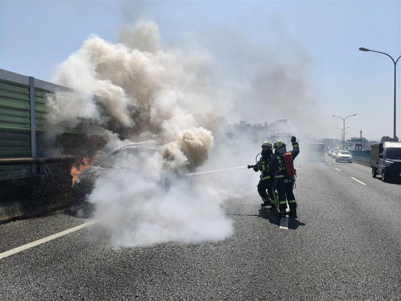 一輛轎車行經潭子路段時因不明原因竄出火勢。（圖／翻攝畫面）
