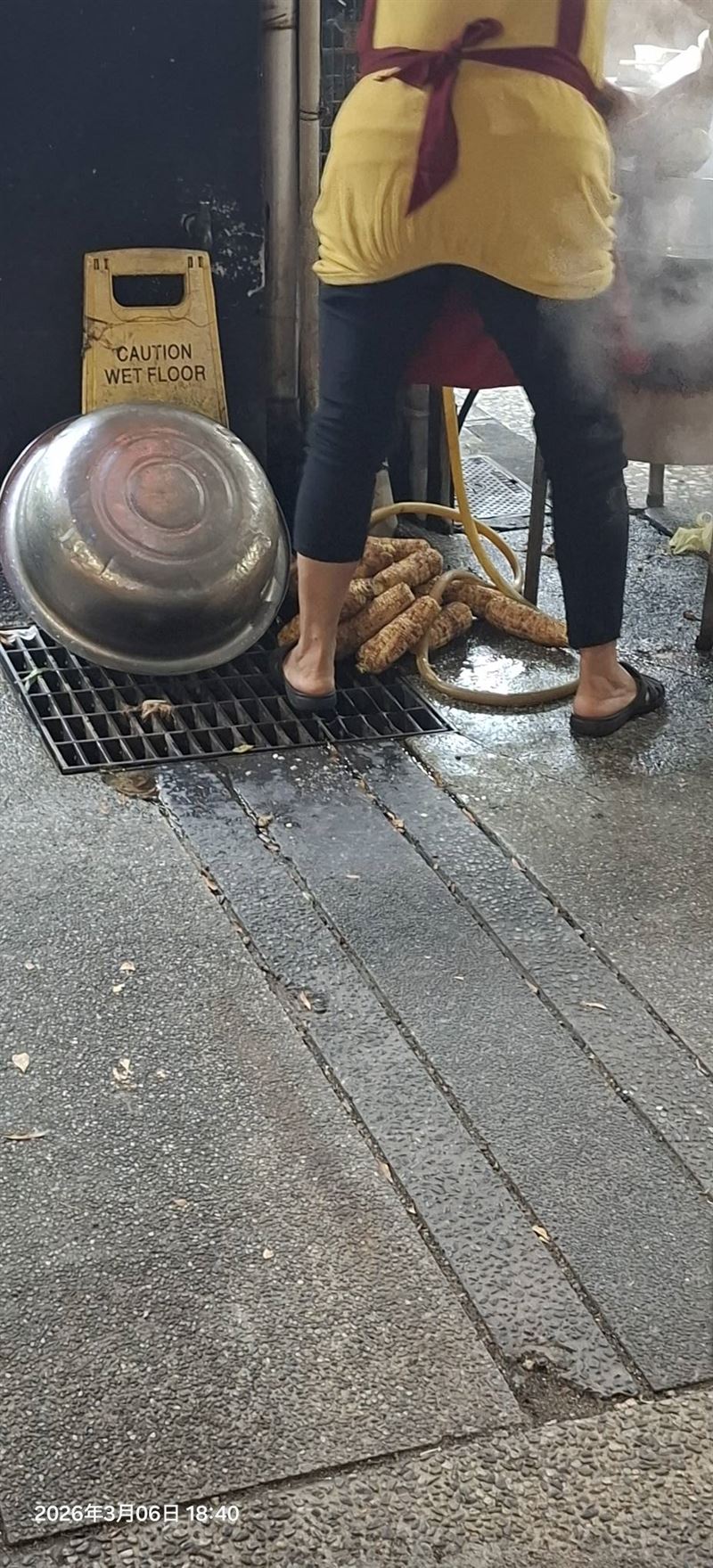 台中北屯中清路一家烤玉米爆發食安疑慮，民眾目睹老闆娘將烤過的玉米堆在水溝蓋上。（圖／翻攝自爆料公社）