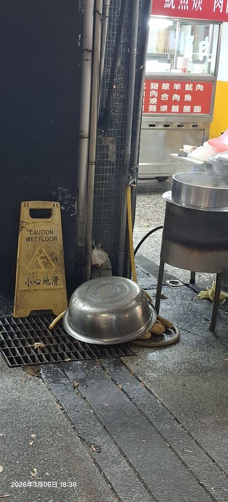 民眾指控老闆娘將洗過的烤玉米堆在水溝蓋上，隨後直接放進鍋內烹煮。（圖／翻攝自爆料公社）