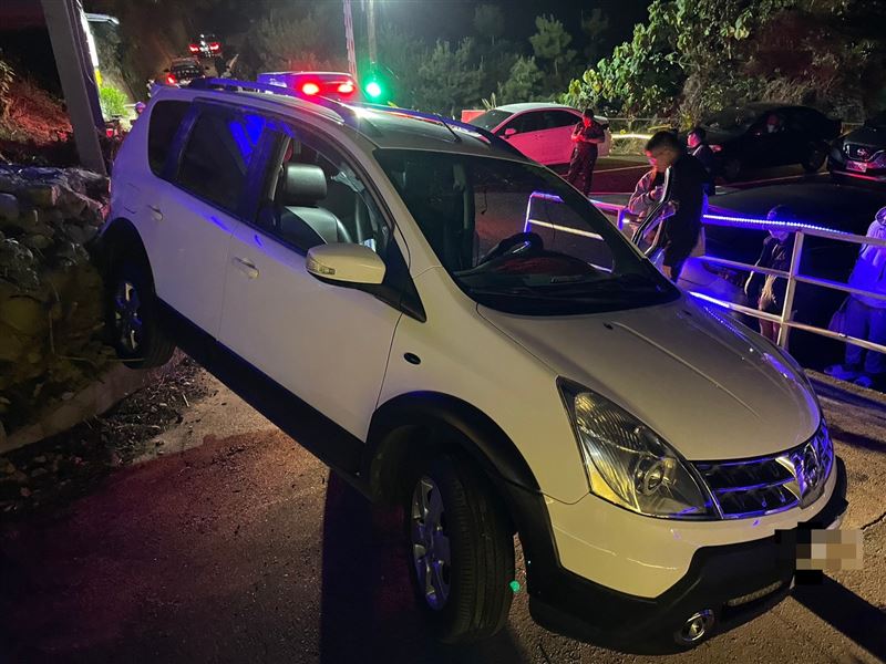 休旅車懸空卡在邊坡護欄上。（圖／翻攝畫面）