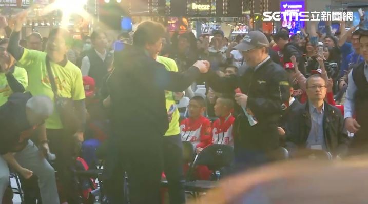 卓榮泰赴台北車站與民眾一同觀看世界棒球經典賽，贏球時與陳義信碰拳。（圖／翻攝畫面）