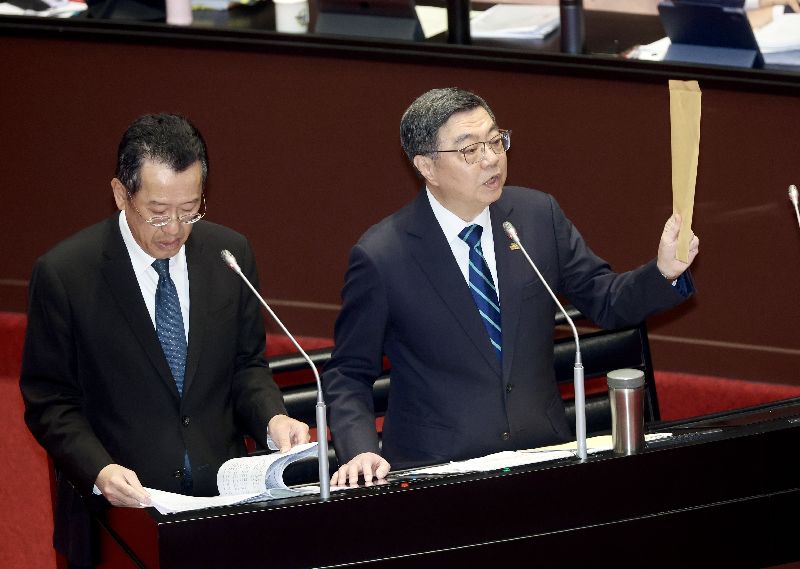 立委質疑行政院長卓榮泰包機前往日本觀看世界棒球經典賽引發爭議，卓榮泰（右）10日在立法院拿出一個牛皮紙袋表示，所有的單據連遊覽車的錢、門票的錢、單據都有，一塊錢都沒有報公費