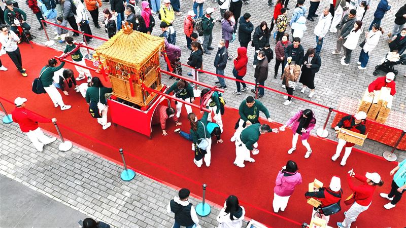 桃園景福宮開漳聖王遶境活動中，信眾依序鑽轎底祈福，象徵消災解厄、祈求平安與好運，展現臺灣傳統信仰文化的熱情與虔誠。（圖／必紅演藝提供）