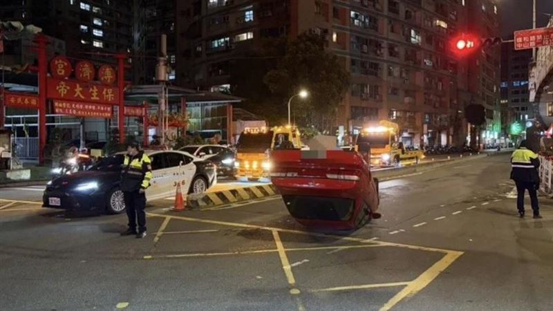 張男駕駛小客車自撞中央分隔島,整台車側翻路中。(圖/翻攝畫面)