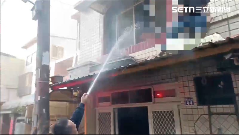 男屋主在屋簷上請消防員趕緊救在4樓的妻小。（圖／翻攝畫面）