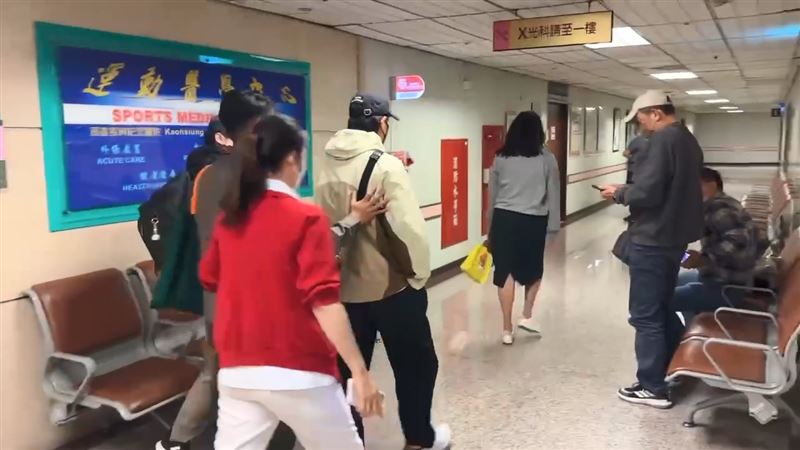 陳傑憲(淺色外套者)抵達長庚醫院後,由工作人員陪同前往診療。(圖/翻攝畫面)