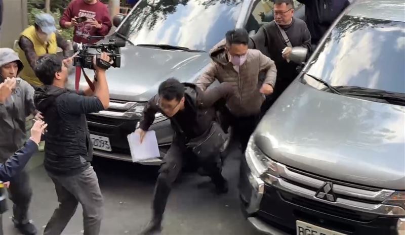 保二總隊員警抓著林男，一邊衝撞推開媒體，一邊狂奔進北檢。（圖／翻攝畫面）