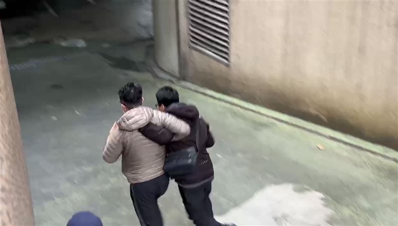 保二總隊員警抓著林男,一邊衝撞推開媒體,一邊狂奔進北檢。(圖/翻攝畫面)