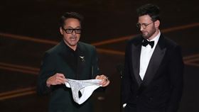 小勞勃道尼在頒獎時還突然拿出一件亮片丁字褲，調侃演員查寧·塔圖（Channing Tatum）。（圖／美聯社／達志影像）