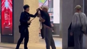 警員揪住酒醉伯的衣領，掏出警棍教訓他，要他「快趴下」。（圖／翻攝自Threads @10j_10.09）