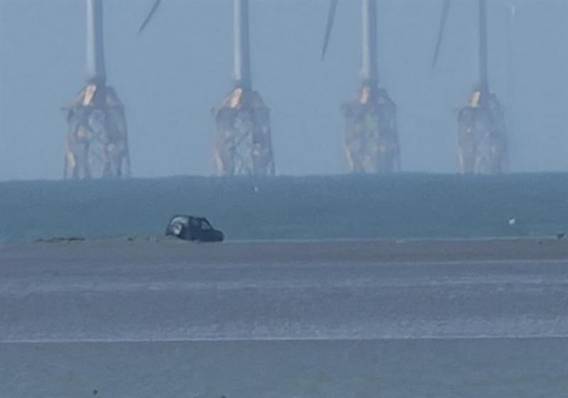 民眾發現一輛吉普車在芳苑鄉永興海埔地載浮載沉，車主已脫困，正聯繫拖吊車吊走。(圖／民眾提供)
