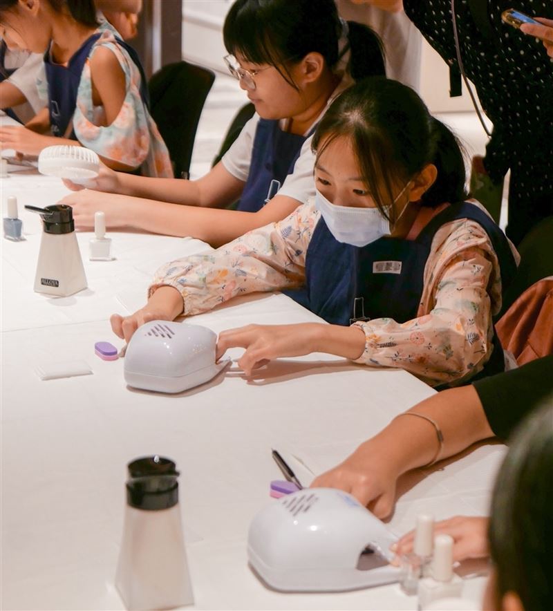 誠品生活新店｜童言童嶼大冒險｜1F中廣場拱門｜週末限定島嶼「親子職涯闖關」齊聚7種大人職業伴孩子想望未來，變身ALLOYA「美甲師」為媽媽換上春日彩甲。（圖／品牌業者提供）