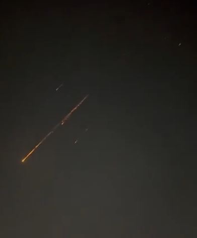 伊朗報復打擊，以色列上空出現飛彈掉落的流星般火光。（圖／翻攝自X平台 @HotBeatNews）