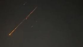伊朗報復打擊，以色列上空出現飛彈掉落的流星般火光。（圖／翻攝自X平台 @HotBeatNews）