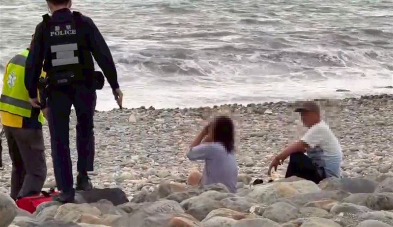 婦人情緒激動走進海中，被雷森救上岸。（圖／翻攝畫面）