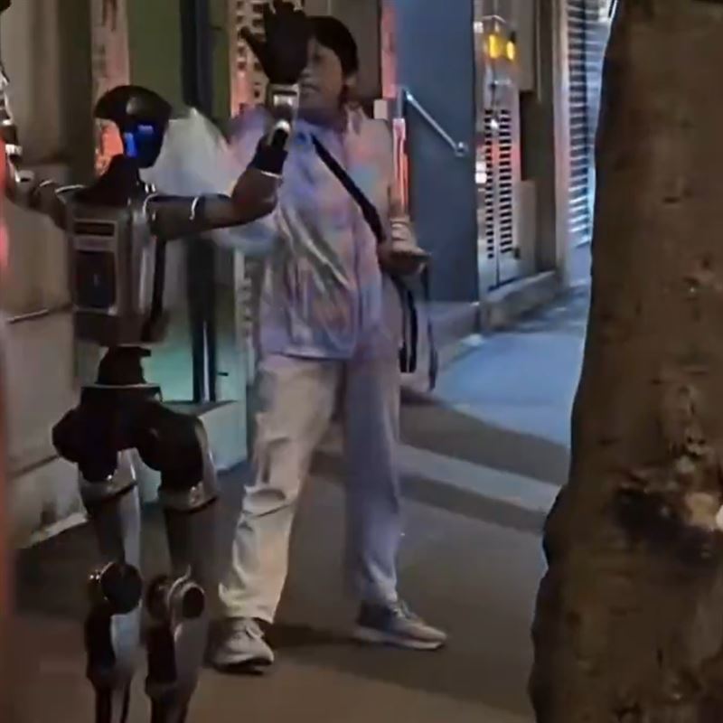 晚上的澳門街頭，一位婦人被人形機器人嚇到。（圖／翻攝自微博）