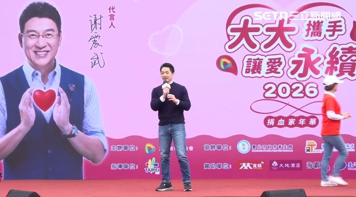 謝震武並沒有出席活動,蔣萬安和印有謝震武的背板同框(圖/翻攝畫面)