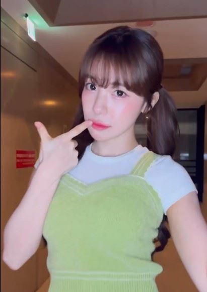 影片中，李多慧以雙馬尾造型亮相，穿著綠色針織背心搭配白色上衣與牛仔褲，整體風格清新俏皮。（圖／翻攝自李多慧Threads）