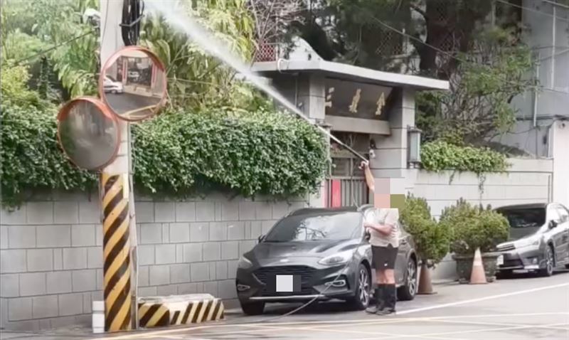 男子長期在馬路邊噴灑消毒水,引發熱議。(圖/翻攝自Threads)