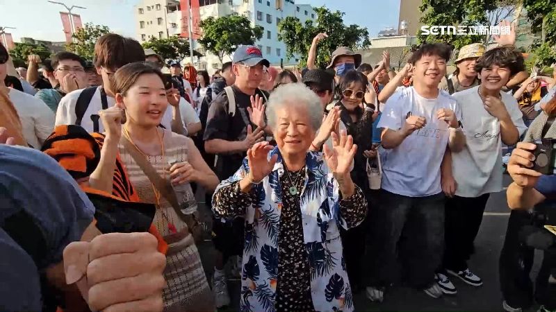 90歲阿嬤跟著音樂節奏在人群裡跳起來，變成全場焦點