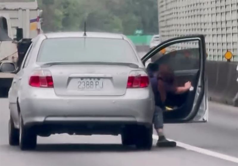 一名長髮女乘客突然打開車門,疑似想要跳車,她不斷試圖用腳踩地減速。(圖/翻攝自threads)