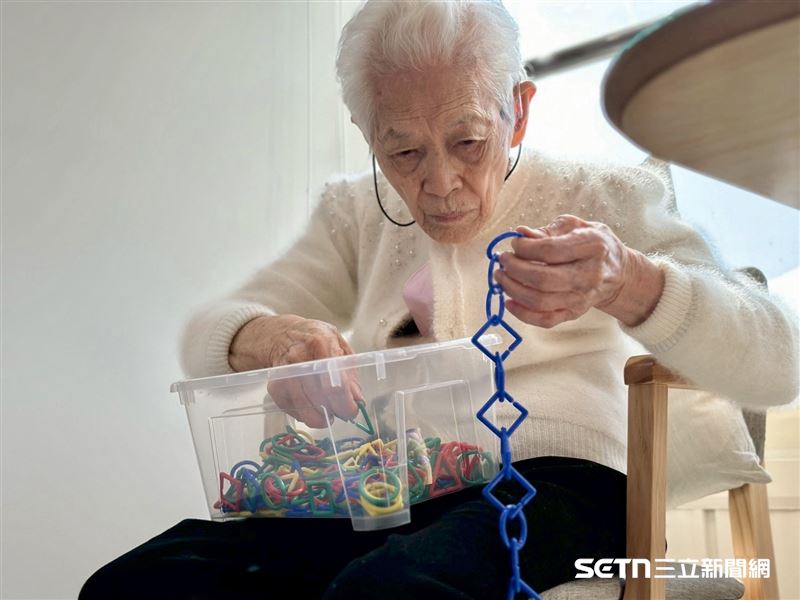 「資深農婦」高阿嬤最喜歡坐在南屯老拾光的這個角落,邊曬太陽邊進行訓練手眼協調的課程活動,動作相當快速,完全看不出已經97歲。(圖/弘道基金會授權提供)