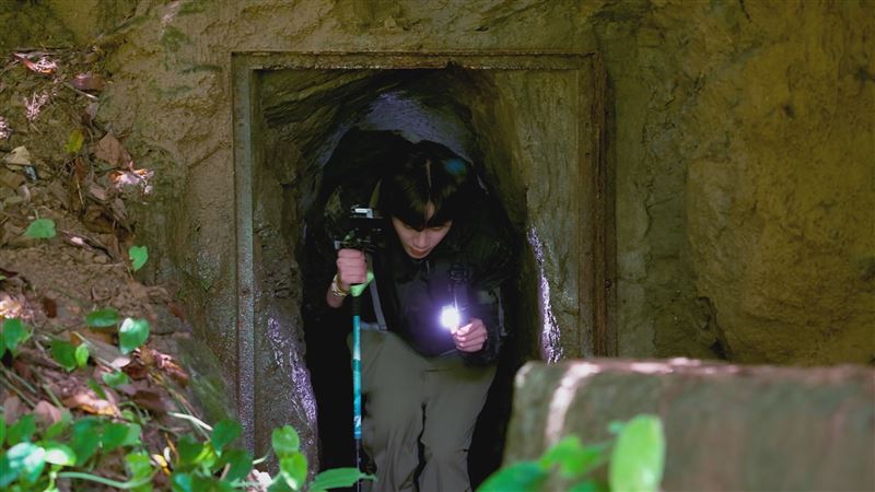 隱藏在山壁間的隧道探險中，李濬榮率先探路走第一。（圖／客家電視台提供）