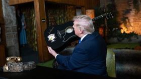 美國總統川普參訪貓王故居，受邀為一把復刻版吉他簽名，展現貼心的一面，先測試筆的墨水量，避免破壞吉他。（圖／翻攝自X平台白宮帳號）