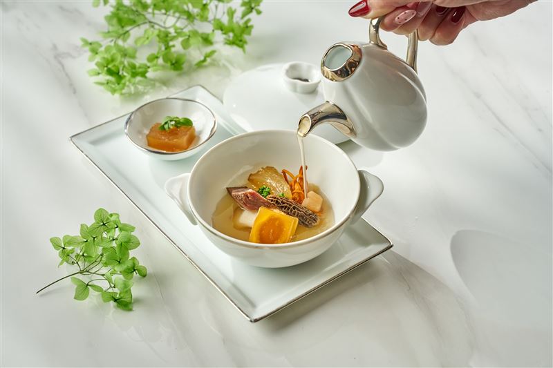 「鮑潤牛湯琥珀凍」嚴選牛大骨、牛筋與和牛臉頰，佐以十餘種時蔬慢火熬煮十小時，將濃醇湯底注入鮑魚並冷凝成天然膠質凍體。「一湯二吃」先品嚐凝凍後的鹹鮮風味，再沖入熱湯回歸濃厚湯韻。（圖／飯店旅宿業者提供）
