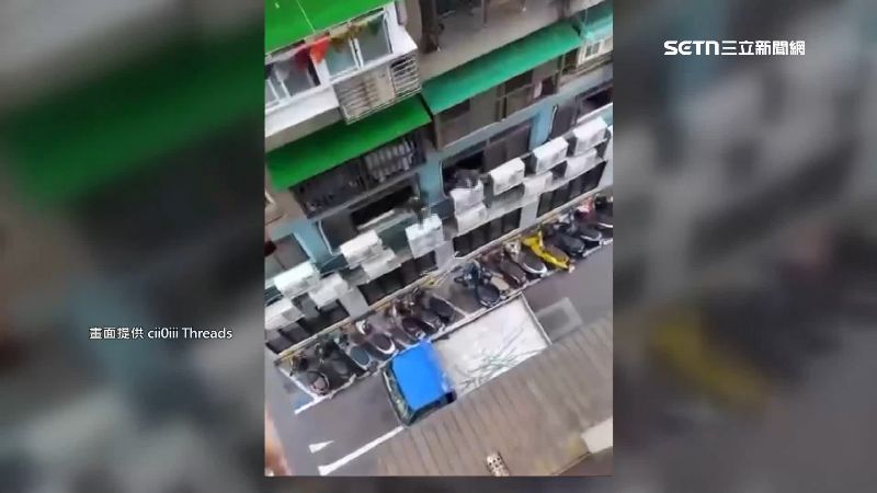 拆除工人把拆下來的鐵窗條從二樓丟到一樓貨車