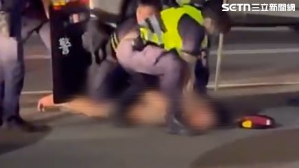 警方不敢大意，手持盾牌壓制男子，因為他手上緊握沾滿血的刀。（圖／翻攝畫面）