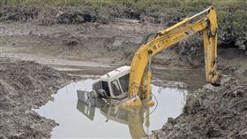 金門浯江溪出海口一輛執行互花米草移除作業的怪手陷入泥灘，油箱已抽空，縣府正研議拖離方案。（圖／翻攝畫面）