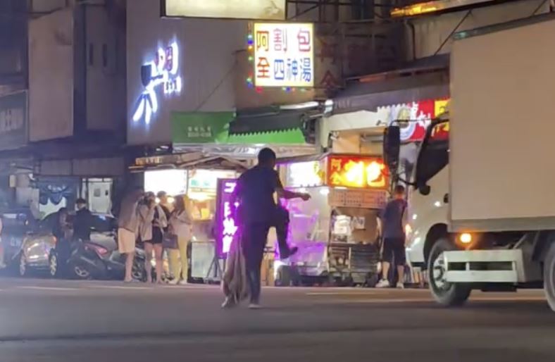 男子在十字路口上手舞足蹈,一旁車流呼嘯而過相當危險。(圖/翻攝自Threads @legolas83849)
