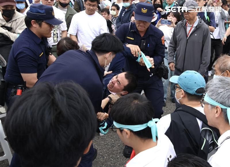 網紅「吃屎哥」游兆霖高喊「柯文哲貪污」,隨即遭警方緊急帶離現場。(圖/記者鄭孟晃攝影)