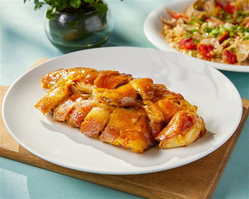 主打粵菜的金龍餐廳順應春日節氣，推出多道經典春季料理。圖為古法吊燒雞，外皮金黃酥脆、肉質細嫩多汁，香氣四溢。（圖／飯店旅宿業者提供）