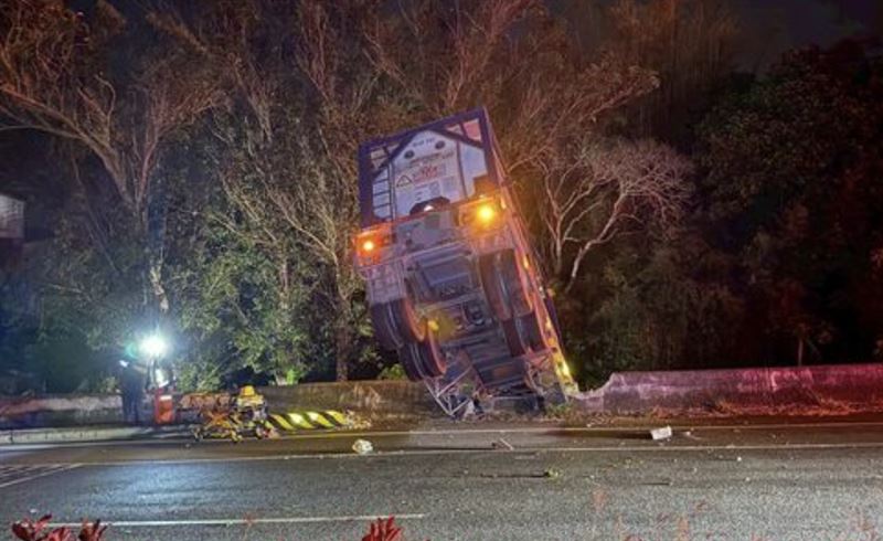 化學槽車後輪懸空，整輛車「倒栽蔥」掛在護欄上。（圖／翻攝畫面）