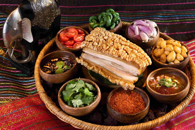 泰國經典料理「泰式脆皮燒肉」同步登上餐檯，搭配特製鮮檸羅望果醬與椰糖黑醋汁，滋味清爽不膩口。（圖／飯店旅宿業者提供）