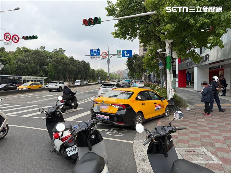 北市閆女駕駛計程車先輾過女行人左腳，再撞上人行道的燈桿才停止。（圖／翻攝畫面）