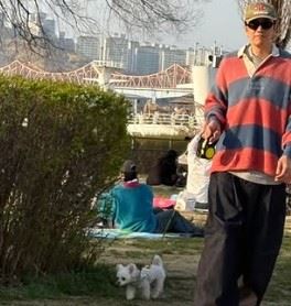 另一畫面則見李先彬坐在野餐墊上，同樣戴著口罩遮掩，但整體氛圍依舊藏不住。（圖／翻攝自Threads）