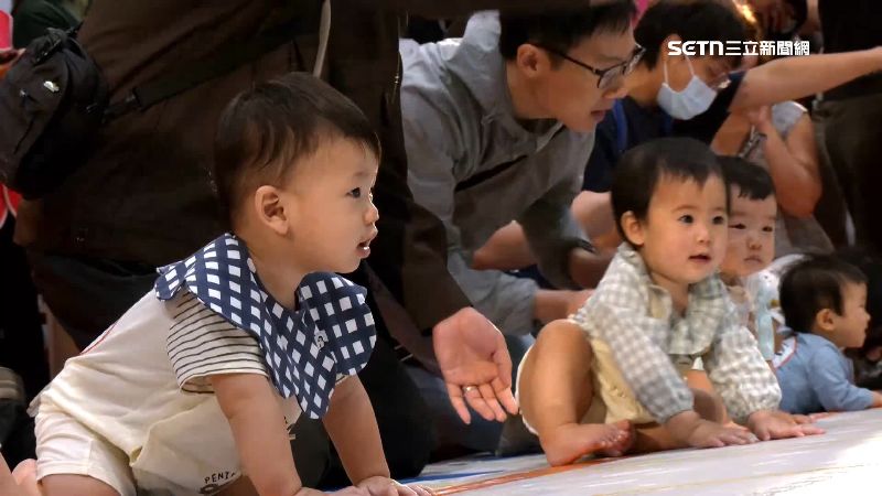 許多家長帶著小孩參加寶寶爬行比賽